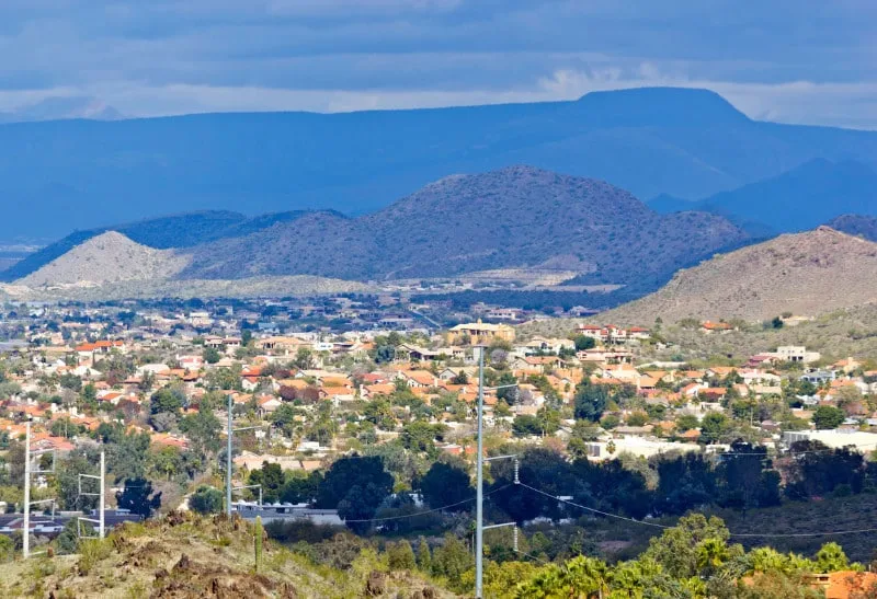 Mountainous landscape with residential area and power lines in Goodyear, highlighting Pipeliners USA’s service area.