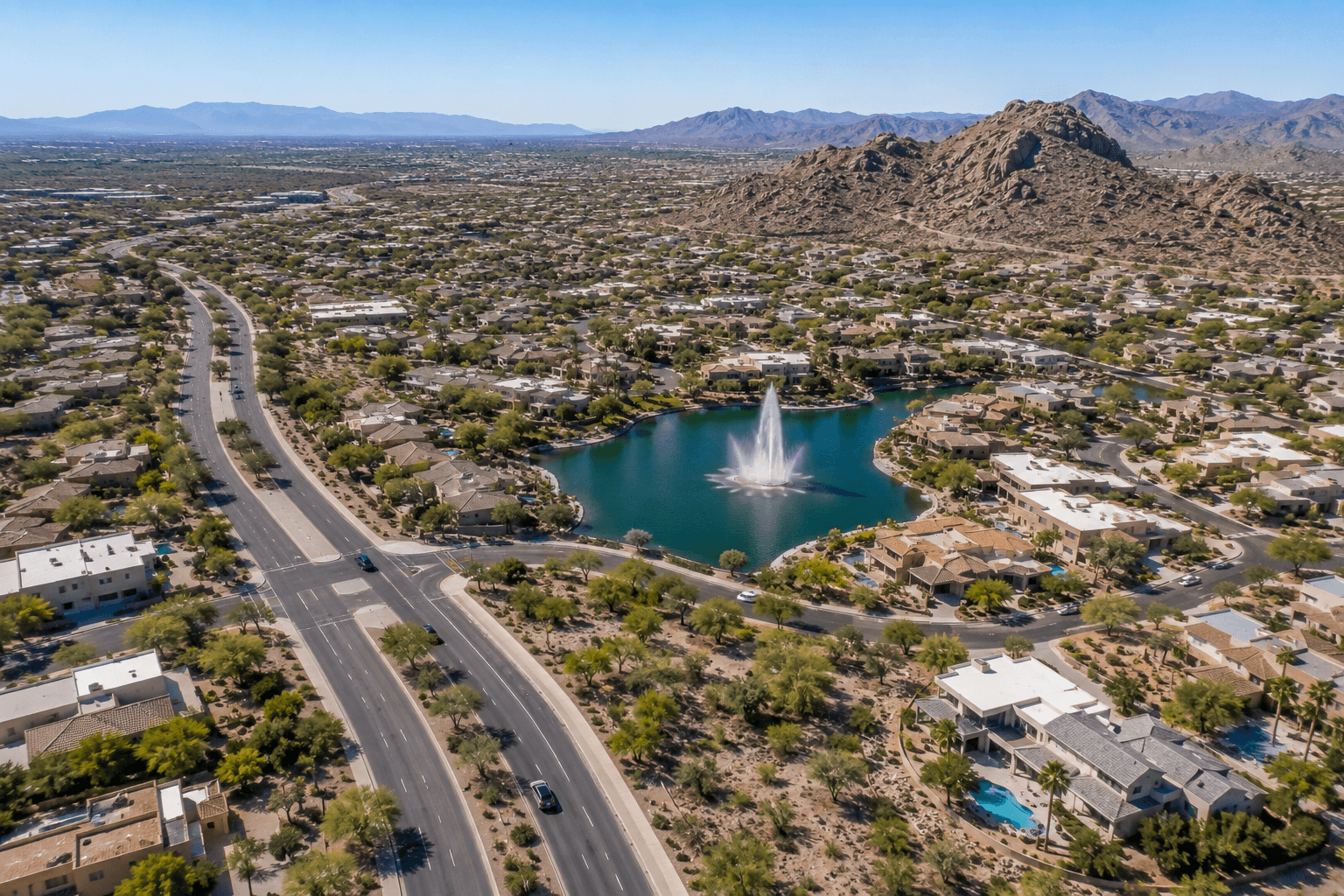 Aerial view of Fountain Hills, Arizona, showing residential neighborhoods, desert landscaping, the central fountain, and surrounding mountains.