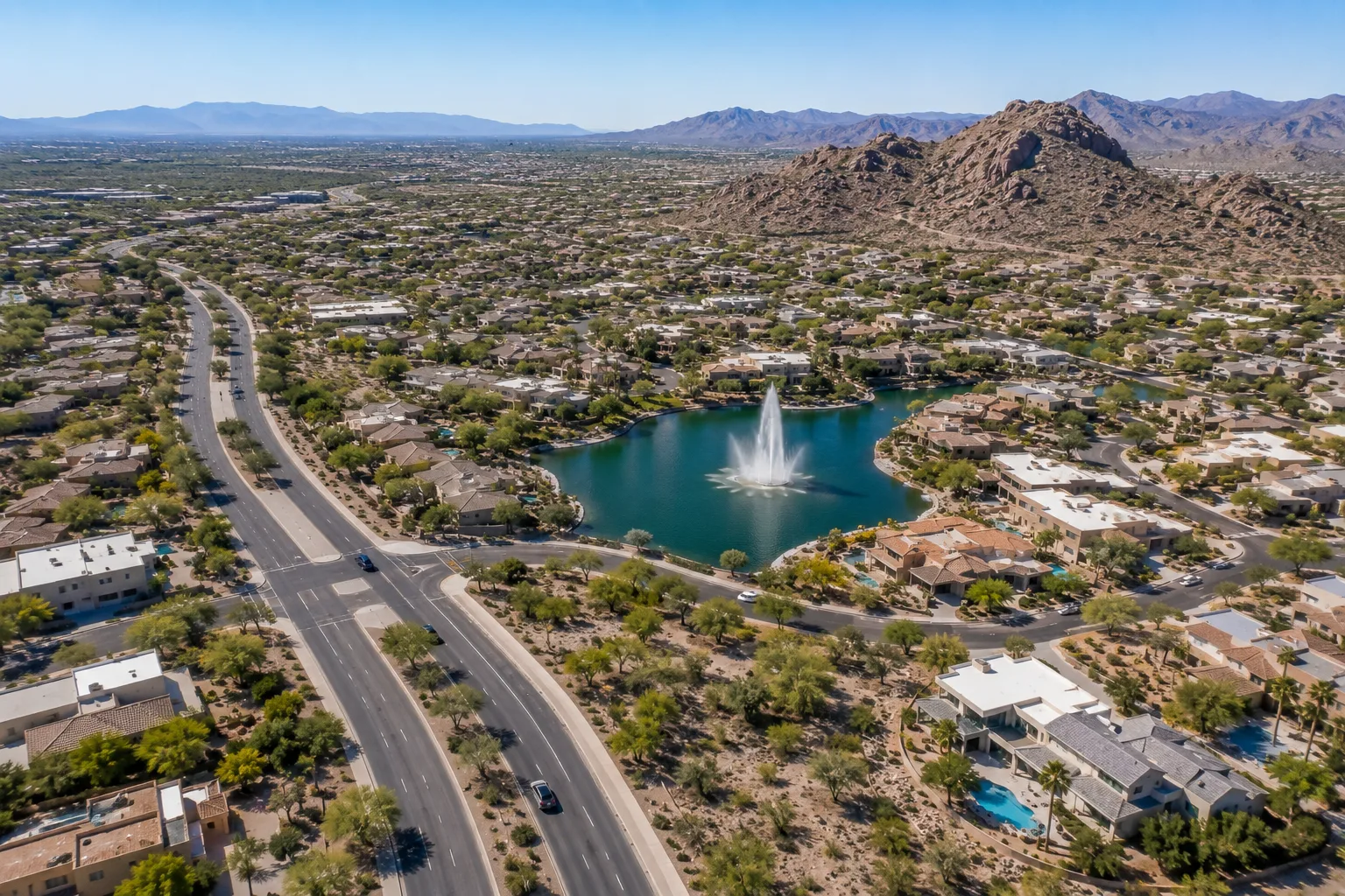 Aerial view of Fountain Hills, Arizona, showing residential neighborhoods, desert landscaping, the central fountain, and surrounding mountains.