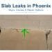 Green paint arrow marking a located spot where a concrete slab meets a block wall at a Phoenix property
